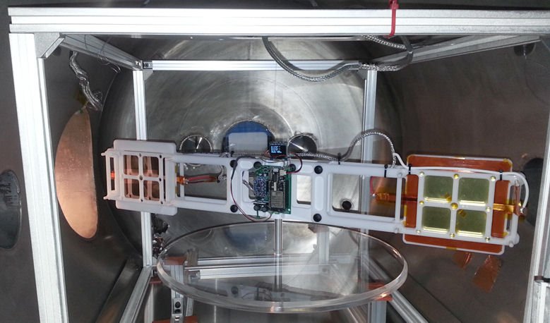 Electrostatic testing apparatus in a vacuum chamber